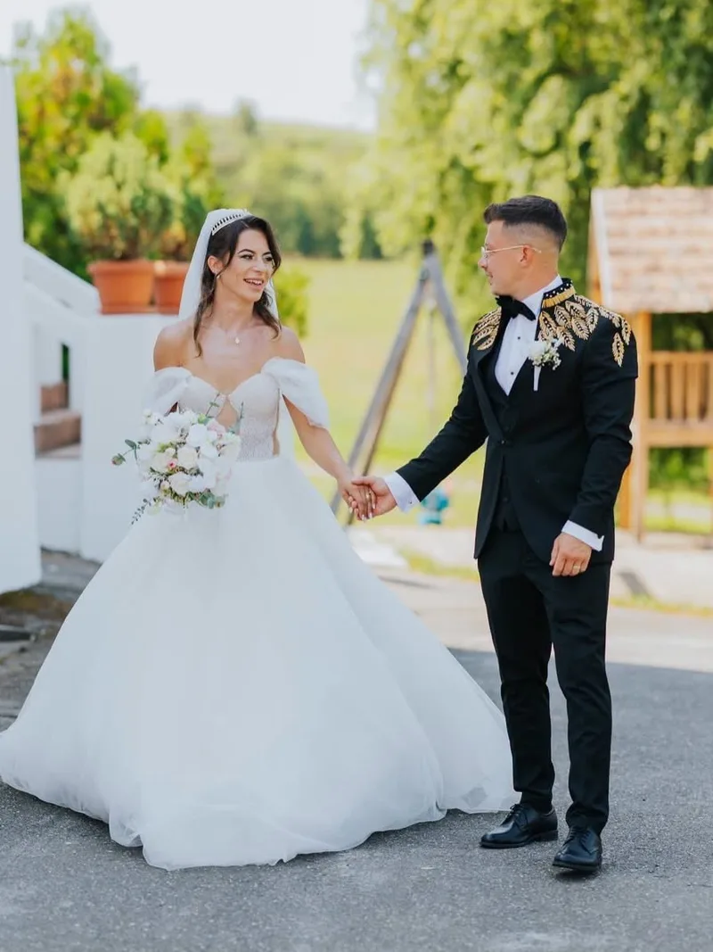 Mire în sacou negru cu broderie aurie, alături de mireasă